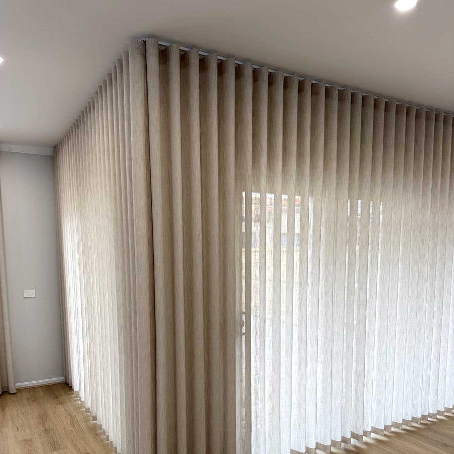 Floor-length sheer curtains across the windows of a new build
