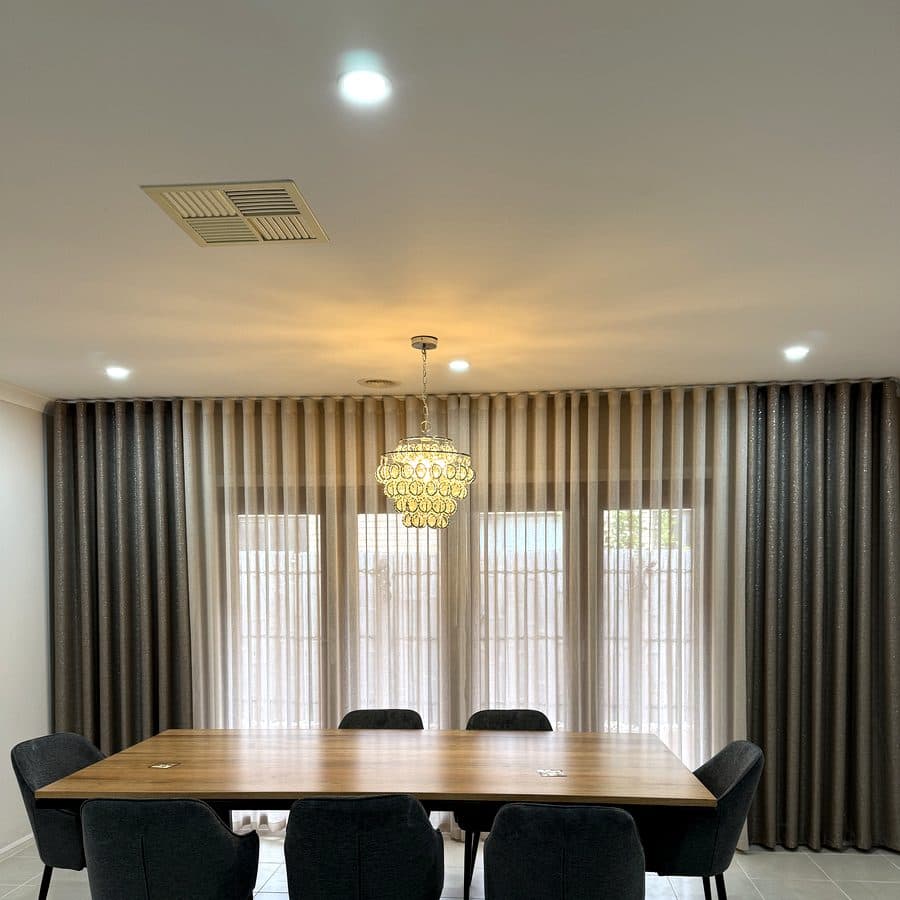 Layered S-fold sheer and blockout curtains in a living room